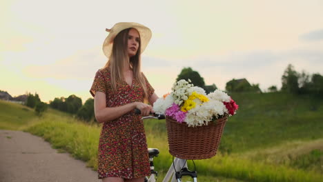 Mädchen-Im-Mittleren-Plan-Im-Kleid-Geht-Mit-Fahrrad-Und-Blumen-Auf-Dem-Feld